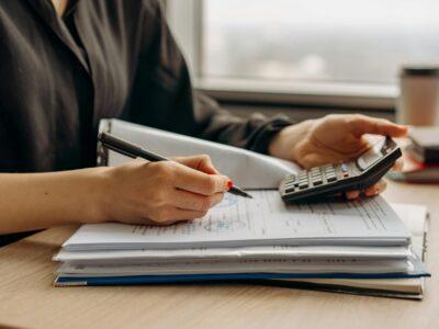 person in long sleeve shirt holding a calculator