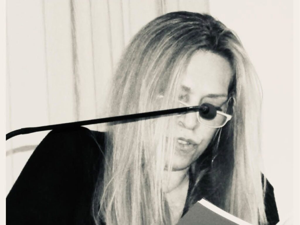 Έφυγε από τη ζωή η Κάτια Ρίσκα, εκδότρια της εφημερίδας «Δήμος και Πολιτεία» 1 Ασπρόμαυρο πορτρέτο της Κάτιας Ρίσκα, που διαβάζει κείμενο μπροστά σε μικρόφωνο