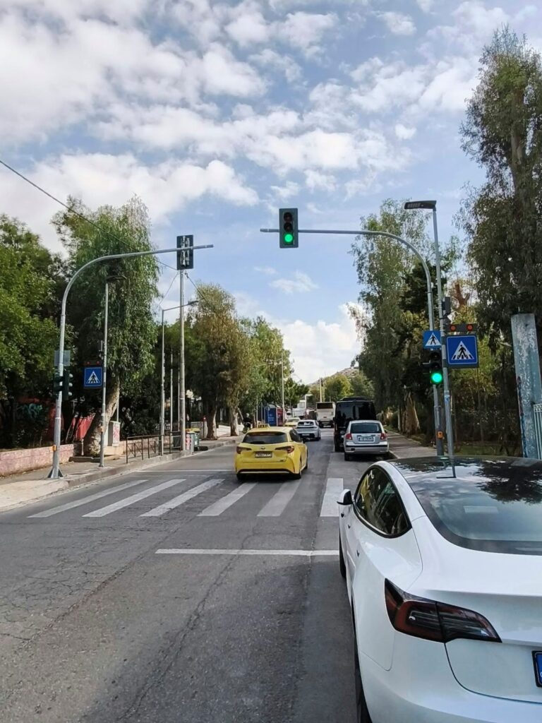 Νέος φωτεινός σηματοδότης στην οδό Αρχιεπισκόπου Χρυσοστόμου Αθηνών στον Βύρωνα 1 Σηματοδότες και διάβαση πεζών σε δενδροφυτεμένο δρόμο, με αυτοκίνητα σε αναμονή